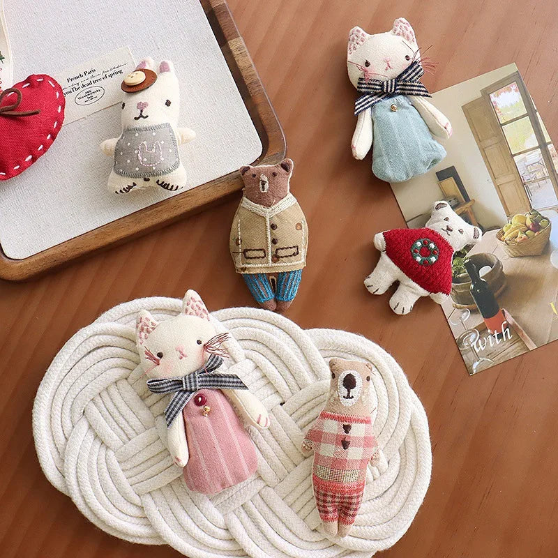 Collection of small plush toys on a wooden surface with a woven mat.