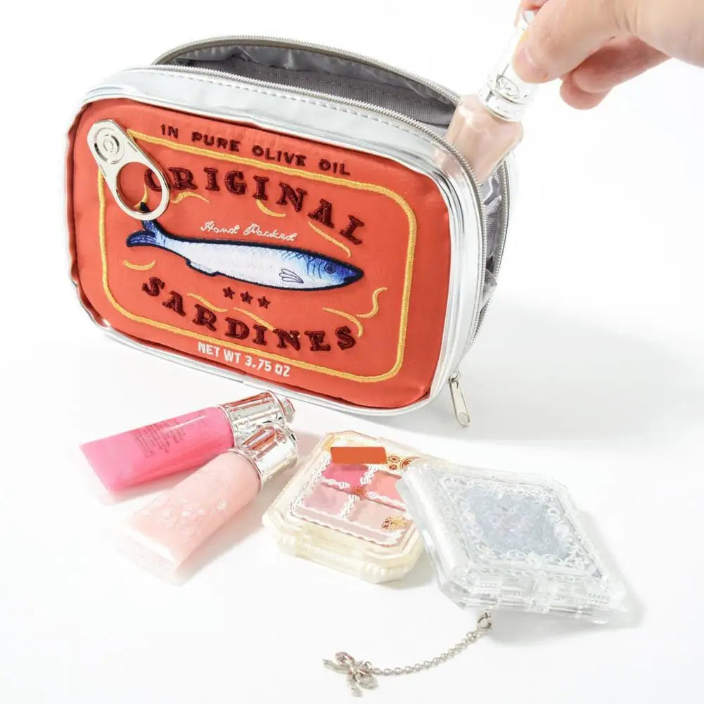 Pouch with sardine label design containing lip gloss and other items on a white background