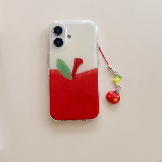 A clear phone case featuring a painted red apple design with green and red leaf details, shown on a phone next to a red and yellow charm strap on a light beige background.
