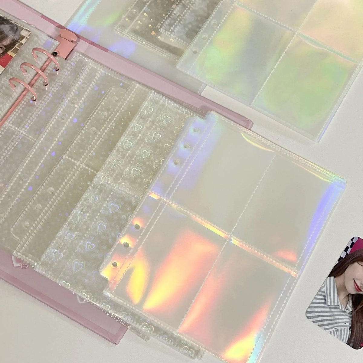 Holographic planner inserts with a pink clip on a white background