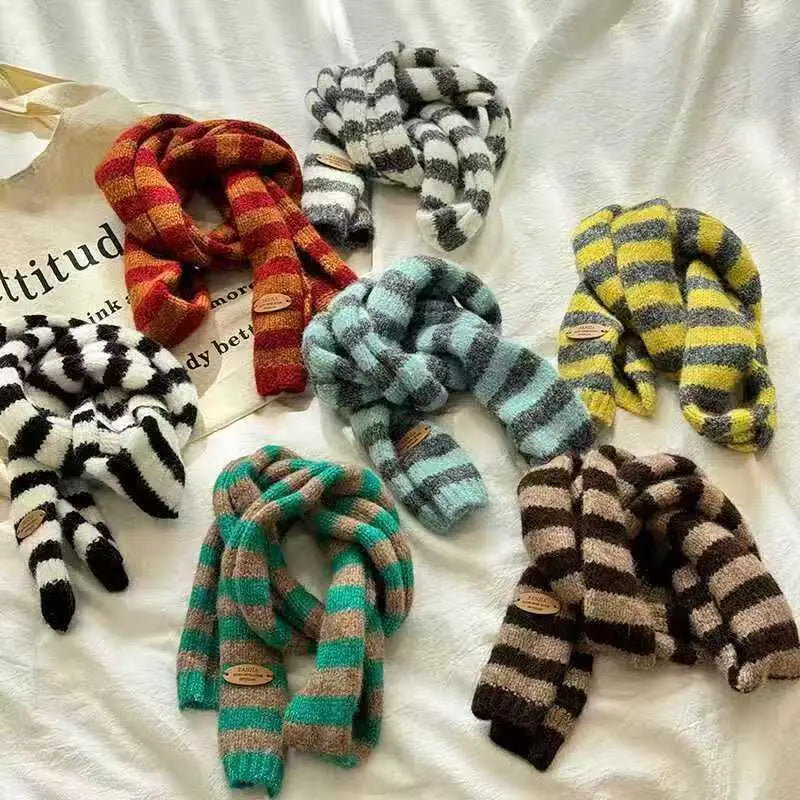 Collection of colorful striped scarves on a textured surface