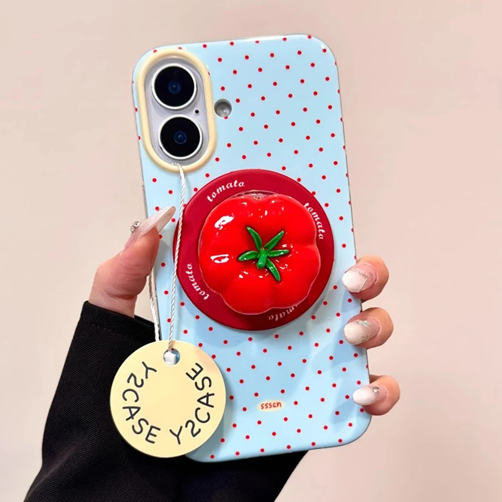 Phone case with tomato design and polka dot pattern held by a hand