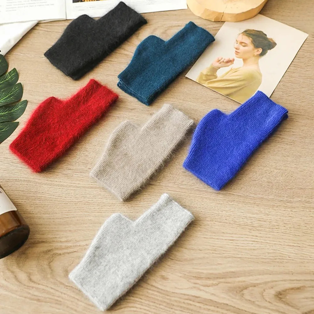 Colorful fingerless gloves on a wooden surface with a magazine in the background.