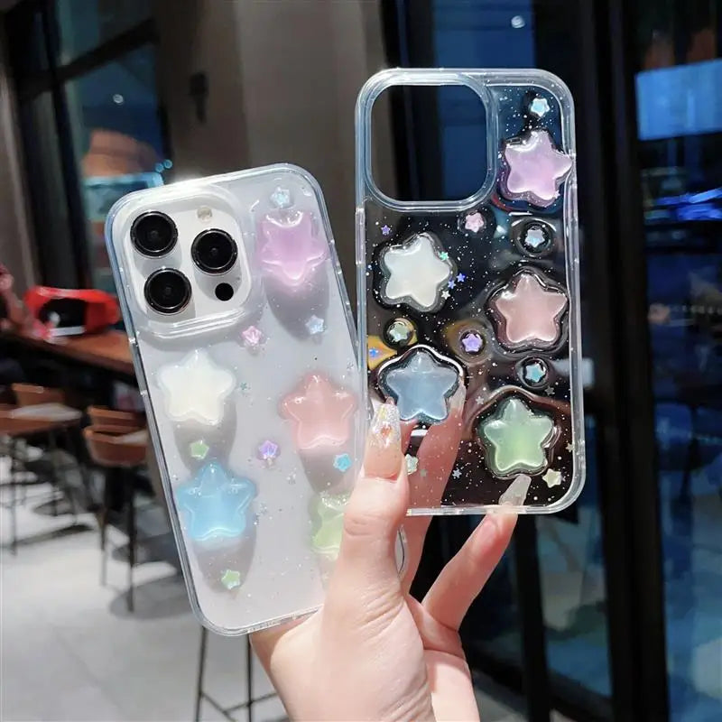 Phone cases with star designs held by a hand in an indoor setting