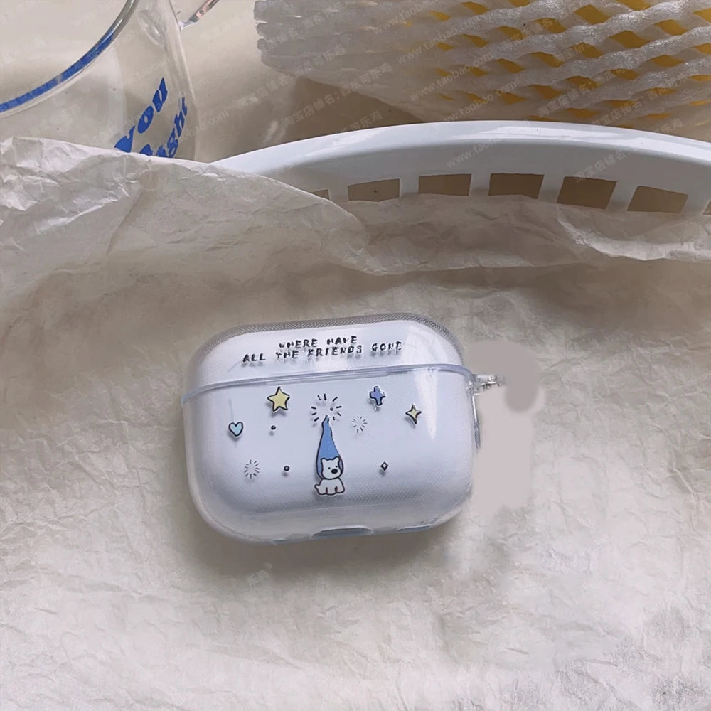 A clear protective case for white wireless earbuds, decorated with a cute cartoon gnome wearing a blue pointed hat, surrounded by stars and hearts, and the text 'WHERE THERE IS ALL THE DIRTY GOOD'. The case is placed on a textured white surface next to a white plastic basket.