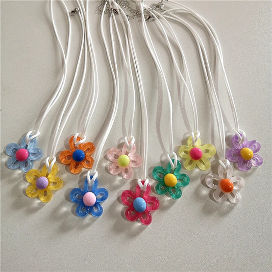 Colorful flower-shaped beads on white strings against a light gray background