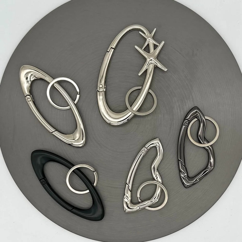 Set of silver and black carabiner clips on a gray background