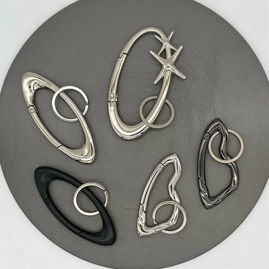 Set of silver and black carabiner clips on a gray background