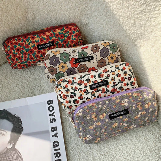 Four floral-patterned pencil cases with 'merciparis' branding on a textured surface.
