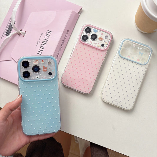 Three polka dot phone cases on a table with a pink box and coffee cup in the background.