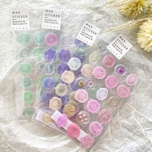 Packaged wax stickers with decorative designs on a textured surface.