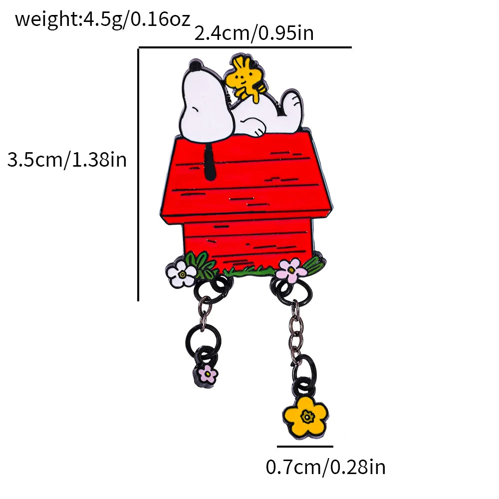 A Snoopy and Woodstock enamel pin shaped like a red dog house, with measurement labels and lines showing dimensions in centimeters and inches on a white background.