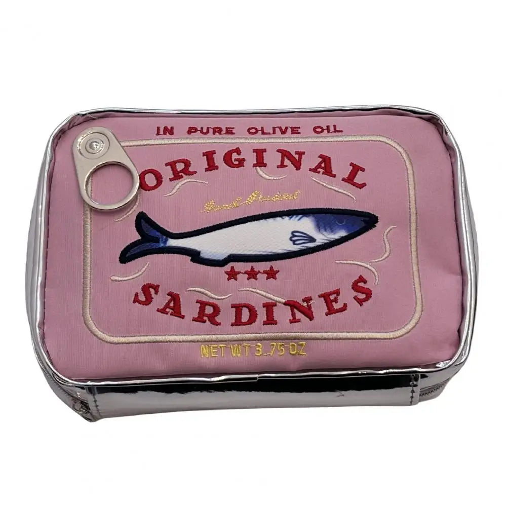 A pink sardine can-shaped pouch with a silver metallic rim and a pull tab, featuring an embroidered sardine illustration and the text 'Original Sardines' on a white background.