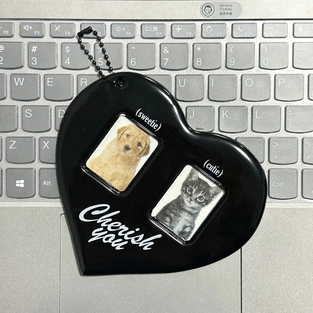 Heart-shaped keychain with pet photos on a keyboard