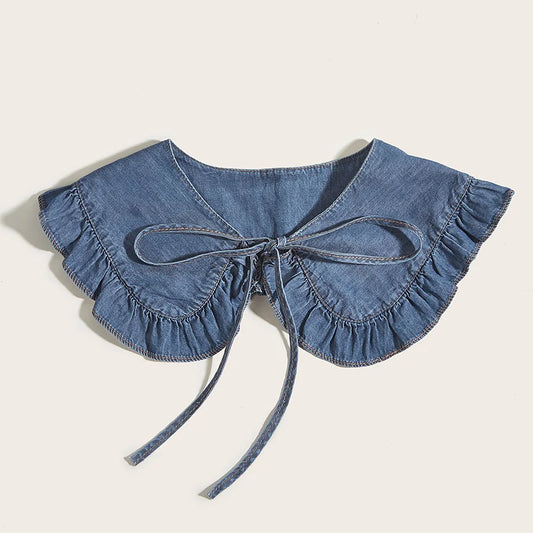 Denim collar with ruffles and a bow on a beige background