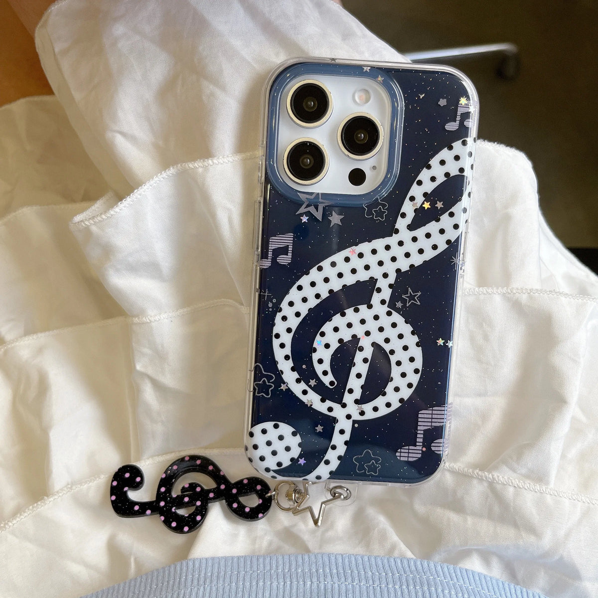 Phone case with music note design on a white fabric background