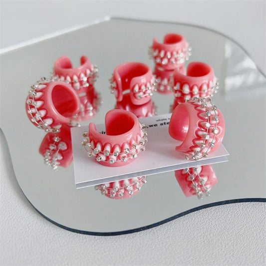 Set of pink dental rings with braces on a reflective surface