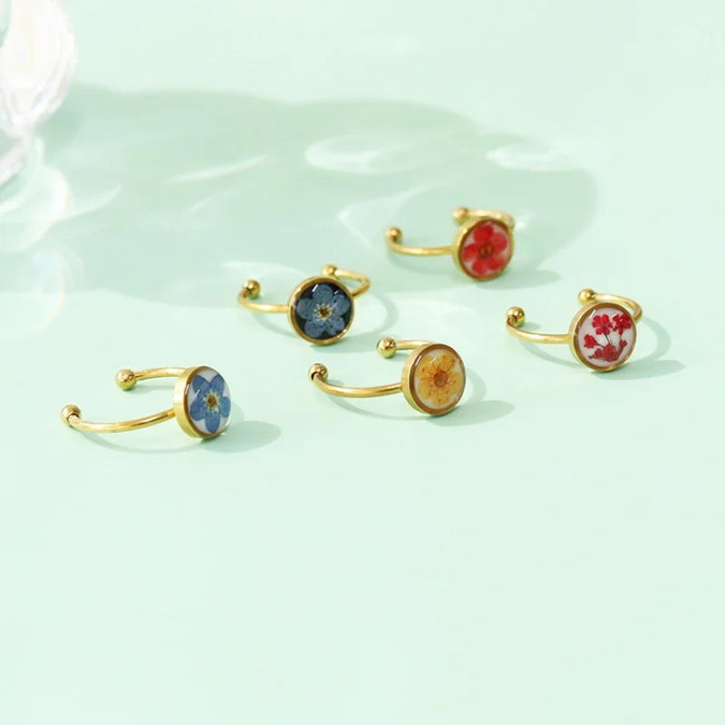 Set of gold rings with floral designs on a light green background