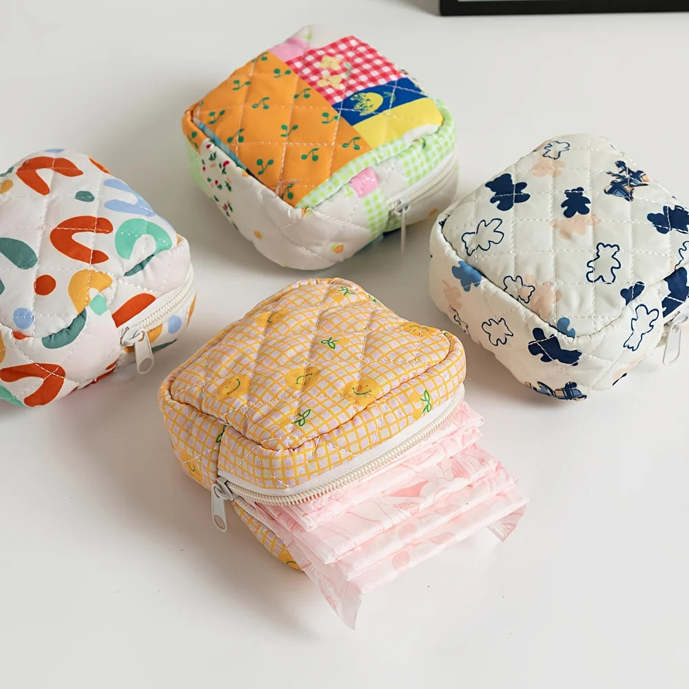 Four colorful quilted pouches on a white surface