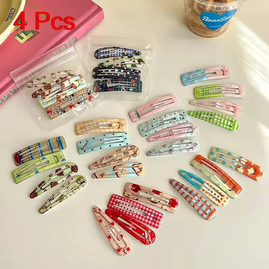 Colorful hair clips on a white surface with a pink box and container in the background.