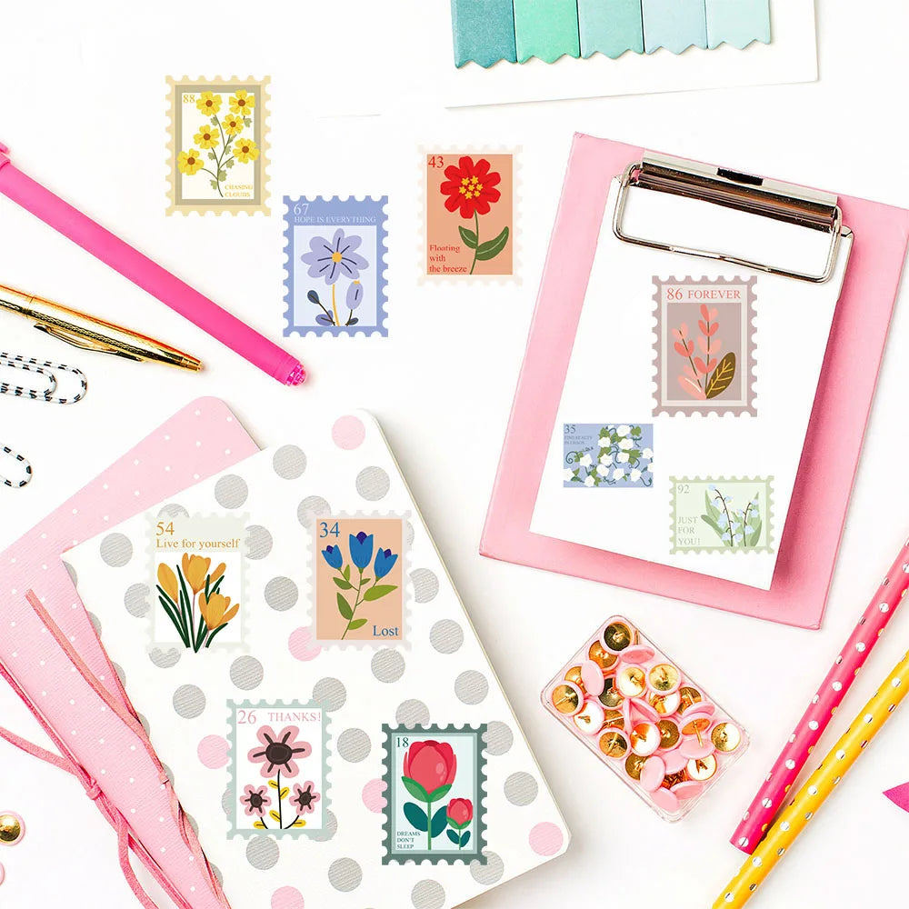 Collection of stationery items including postcards, stamps, and clips on a white background