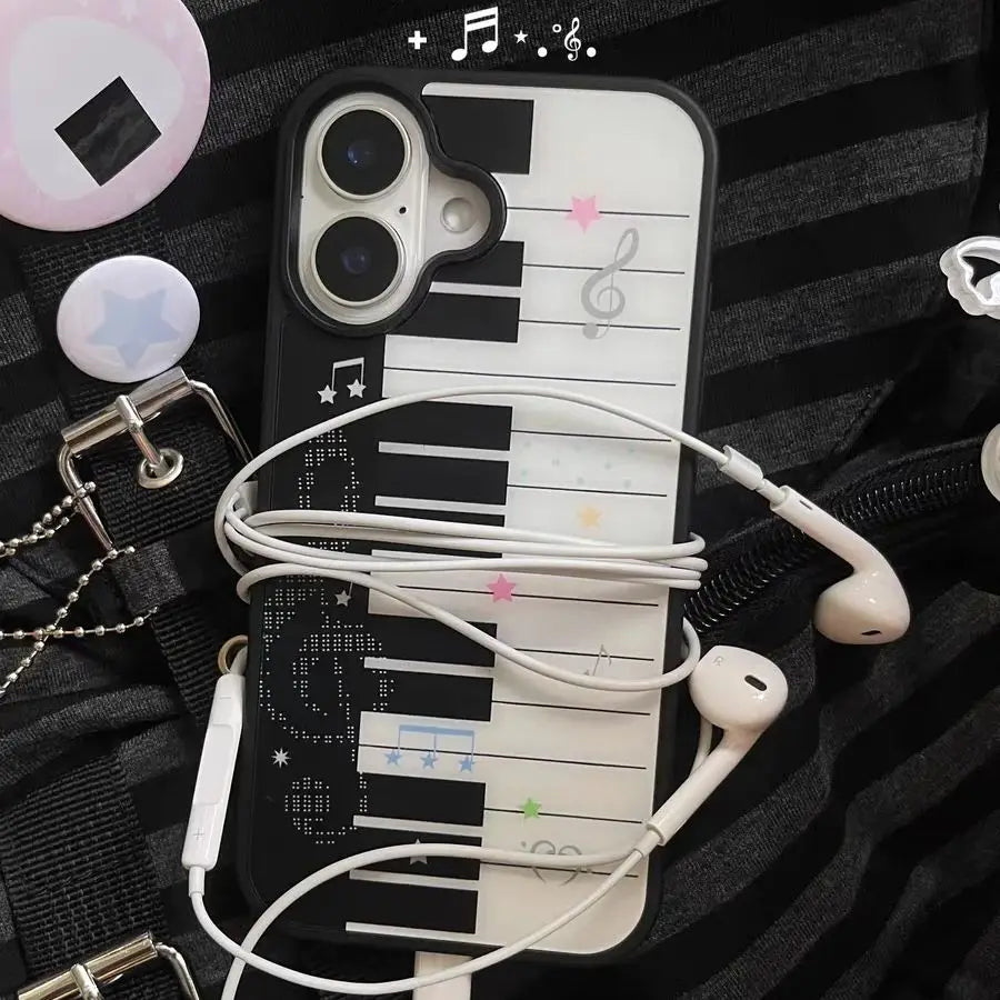 Phone case with piano design and earphones on a textured surface