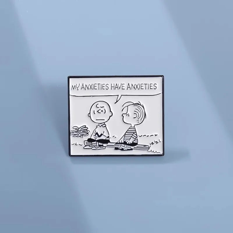 A square enamel pin featuring a black and white cartoon illustration with the text 'MY ANXIETIES HAVE ANXIETIES' at the top, displayed on a light blue background.