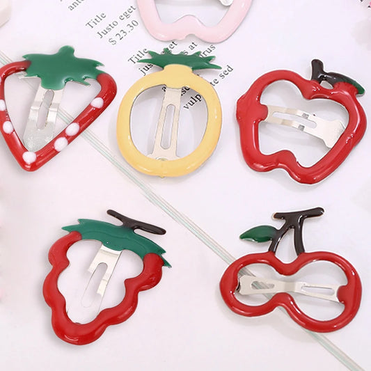 Five colorful hair claw clips shaped like fruit, including strawberry, pineapple, apple, and cherry designs, arranged on a white background with printed text.