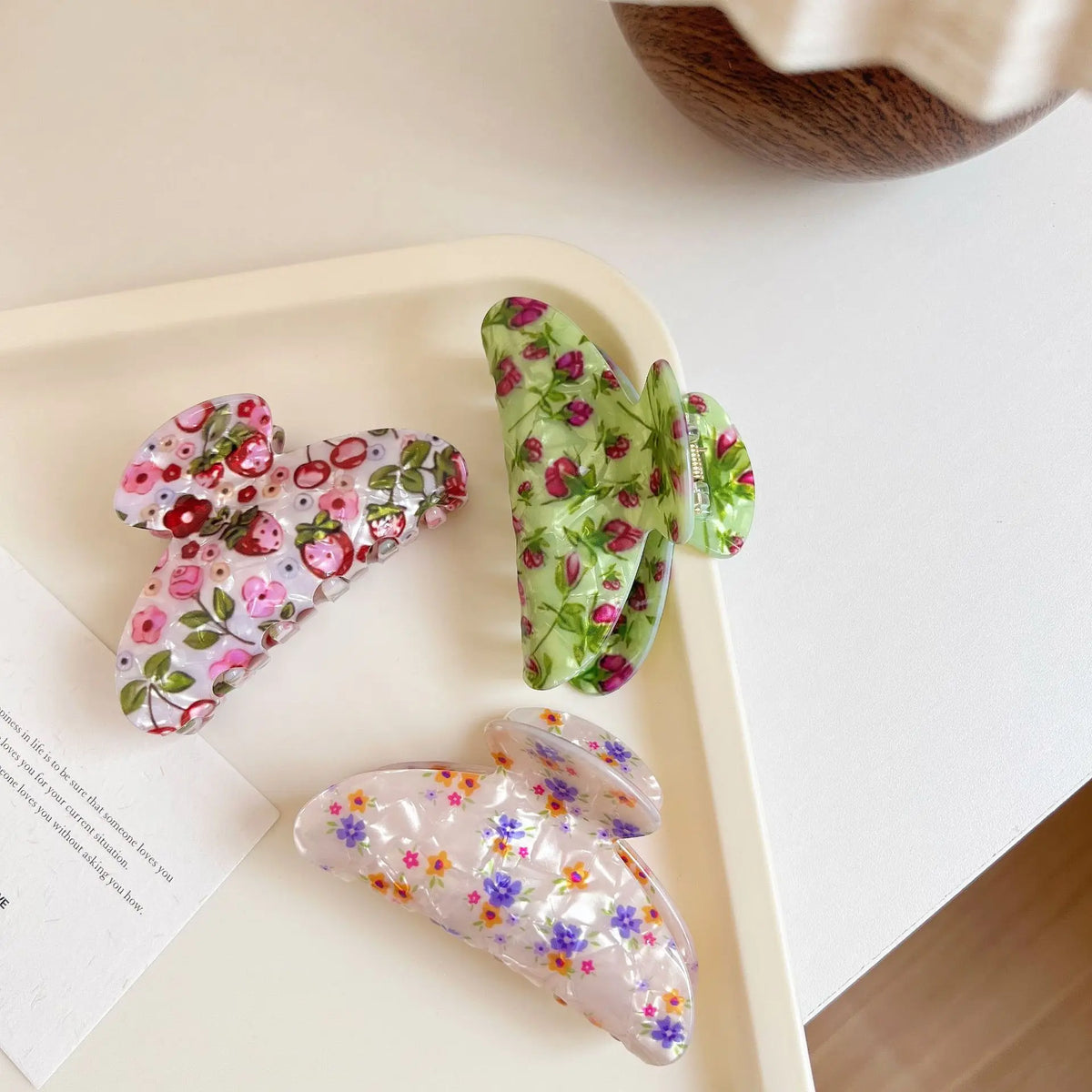 Set of three floral hair clips on a white surface