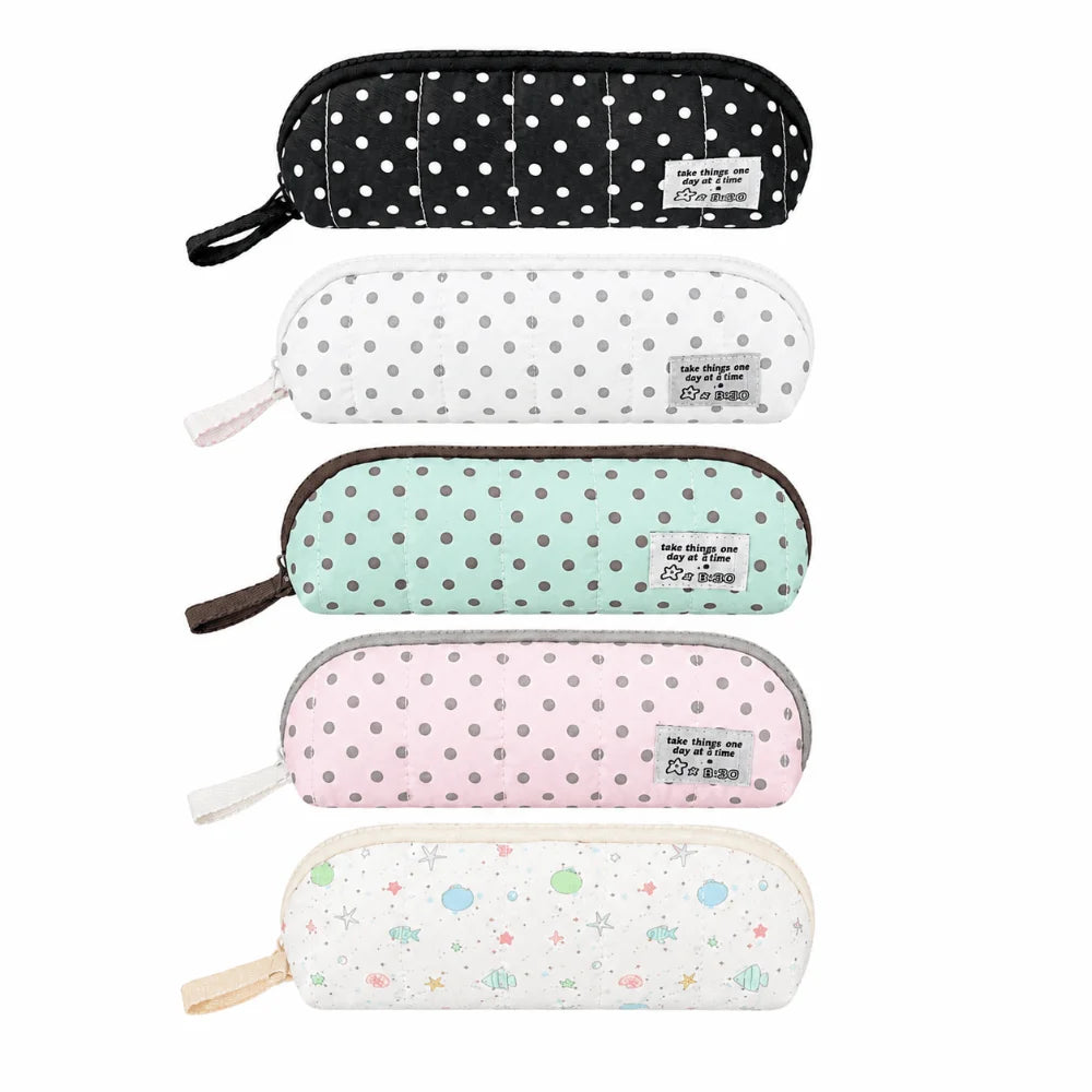 Five zippered pencil cases stacked vertically on a white background, each with a different pastel and neutral polka dot pattern: black with white dots, white with gray dots, mint green with gray dots, light pink with gray dots, and white with multicolor space-themed dots.