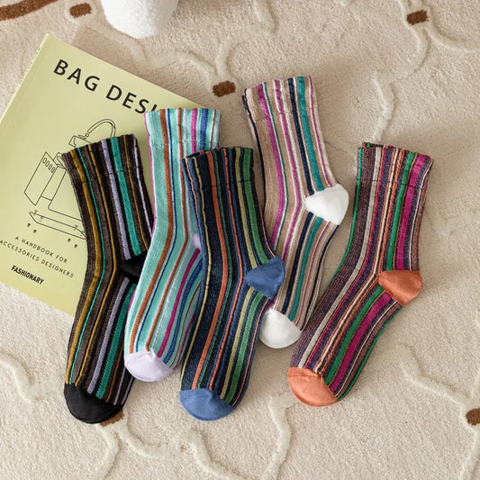 Colorful striped socks on a textured surface with 'Tightarely' branding.