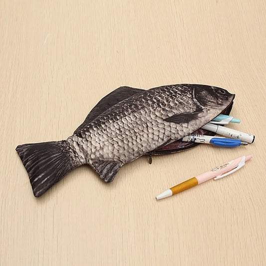 Fish-shaped pencil case with pens on a beige background