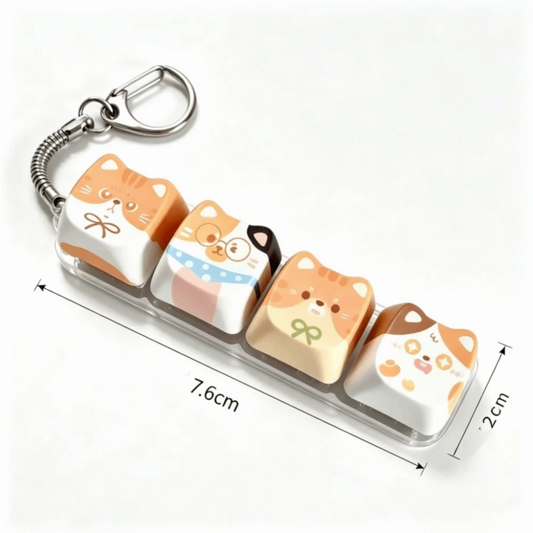 A set of four cute cartoon cat-shaped keycap charms in a clear plastic case with a metal key ring, shown on a white background with dimension lines indicating 7.6 cm length and 2 cm height.