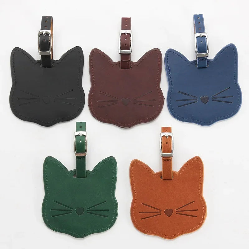 Five cat-shaped luggage tags in black, brown, blue, green, and orange on a white background.