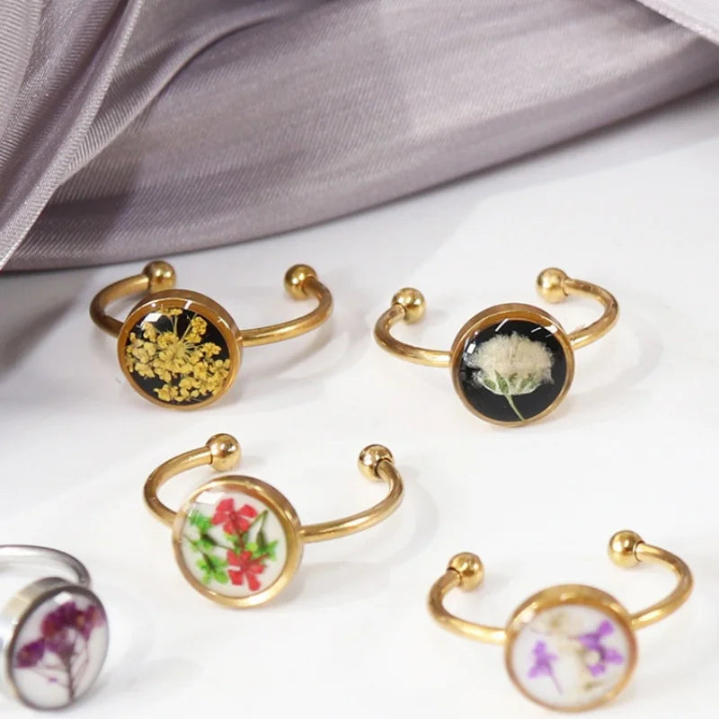 Gold bangle bracelets with floral designs on a white surface