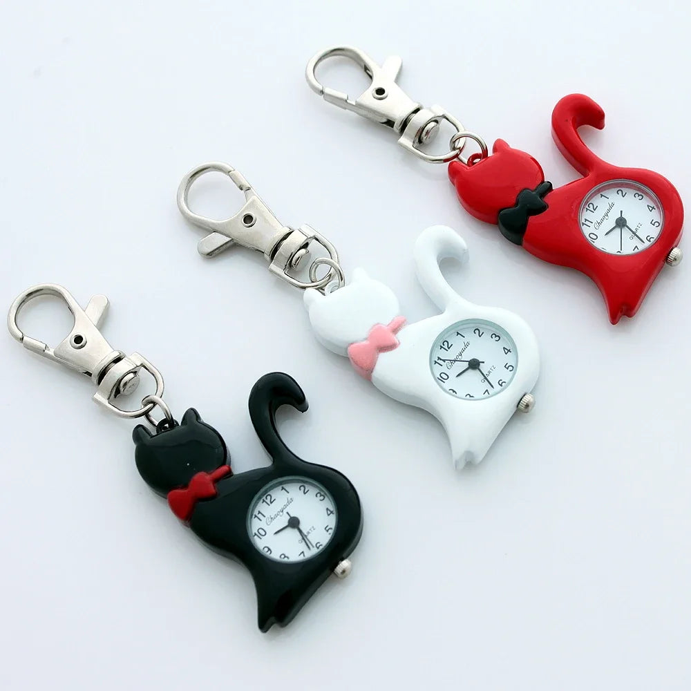 Three heart-shaped cat-shaped pocket watches with cat-shaped keychains in black, white, and red, each with a silver lobster clasp, displayed on a clean white background.
