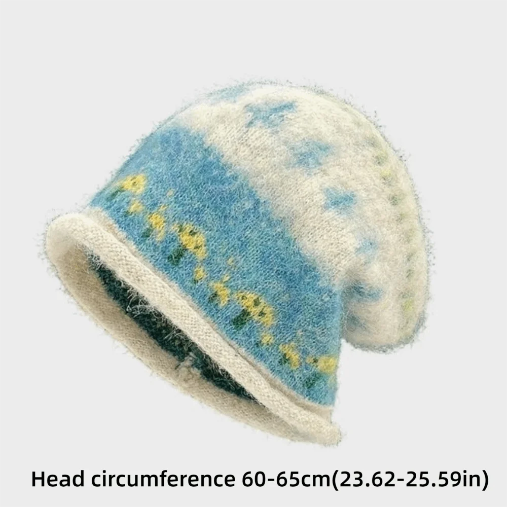A fuzzy knit slouchy beanie hat with a blue and cream tie-dye pattern and small yellow floral accents, shown on a light gray background with text indicating a head circumference of 60-65cm.