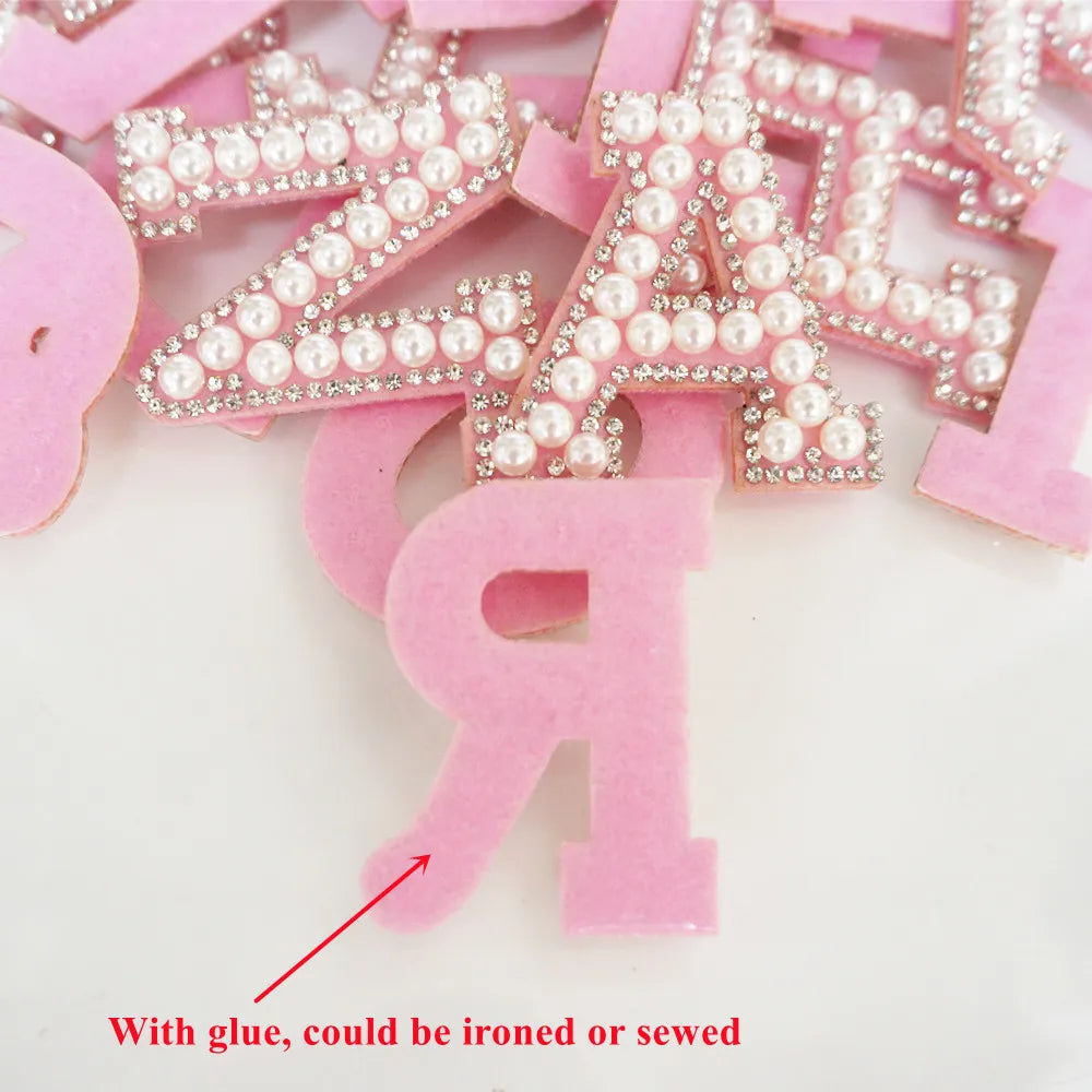 Pink letters with pearl embellishments on a white background