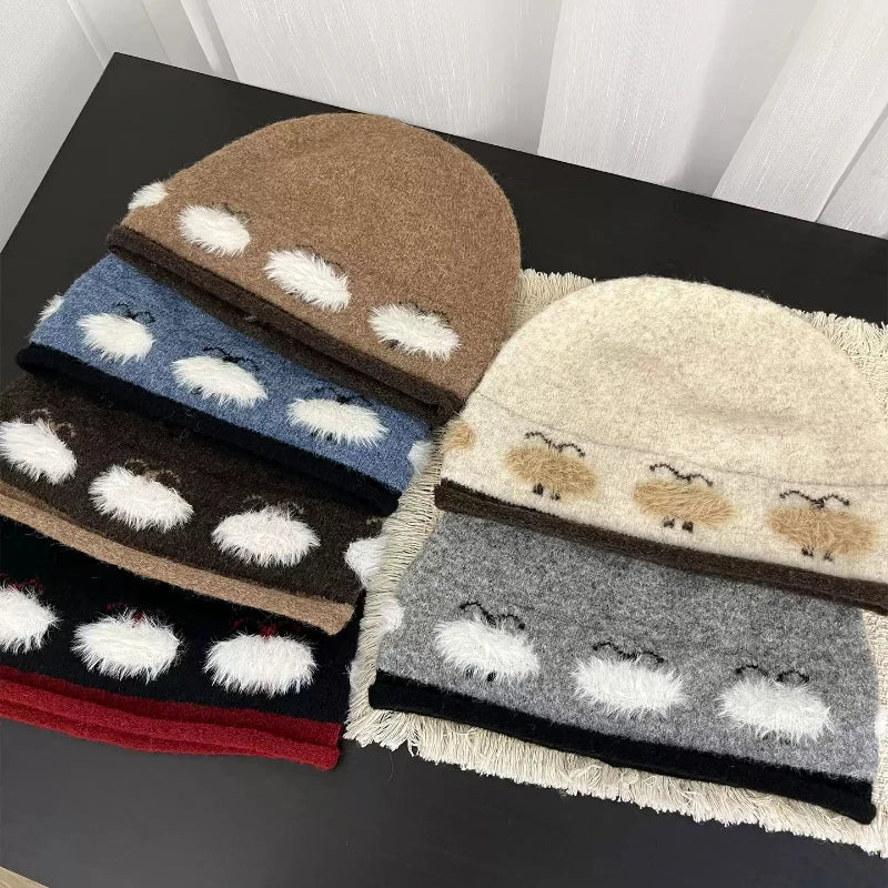 Four fuzzy knit beanies stacked on a dark tabletop, each with a different base color and white fluffy pom-pom details. The visible colors are brown, blue, black, red, cream, beige, and gray.