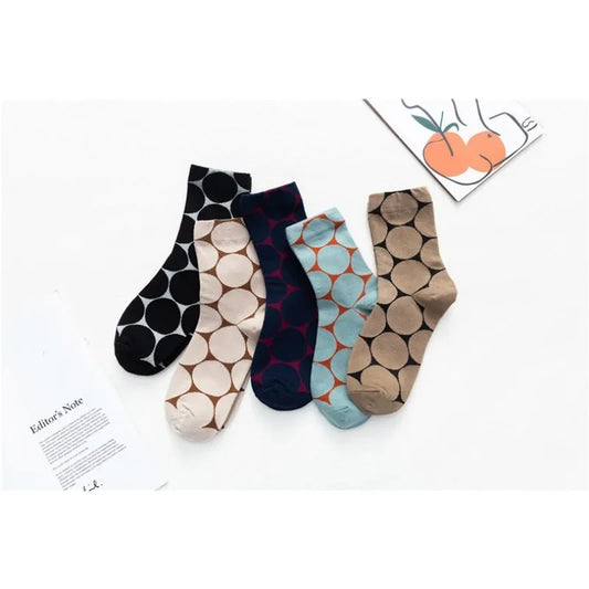 Five patterned socks on a white background with a small card featuring illustrations.