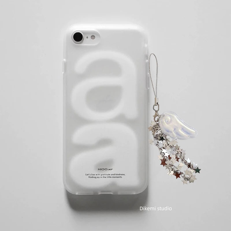 A clear phone case with a large embossed white 'a' design, shown on a light gray background. The case has a small printed brand mark near the bottom and is attached to a decorative silver and white star charm with a small white angel figure.