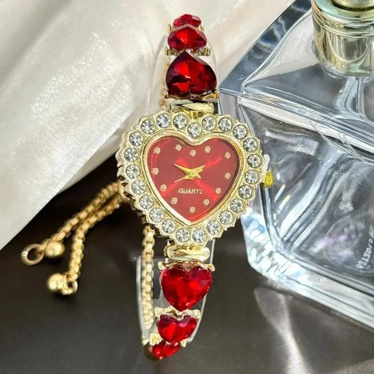 Decorative heart-shaped clock with red gemstones and gold accents on a dark surface.