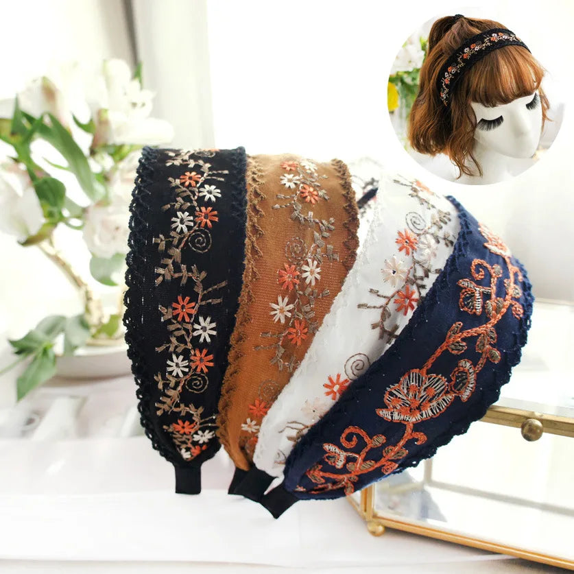 Set of embroidered headbands on a white surface with a blurred floral background