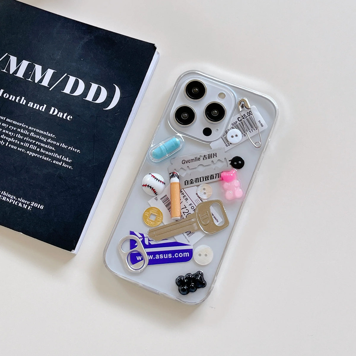 Phone case with various charms on a white surface