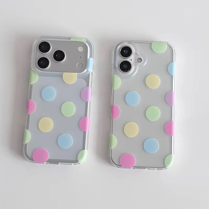 Two clear phone cases with pastel polka dots in pink, yellow, green, and blue, shown on silver smartphones against a light gray background.
