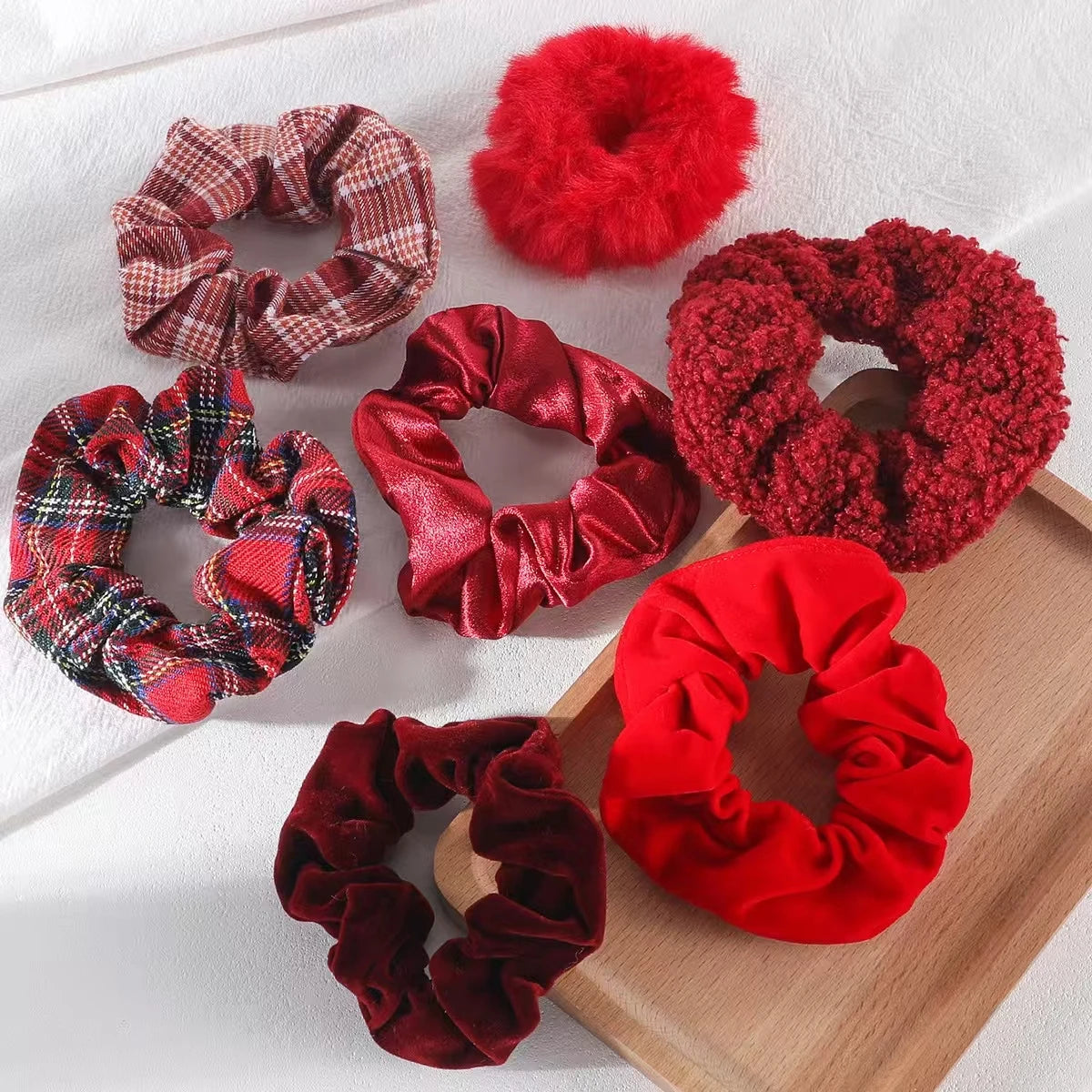 Set of red and plaid scrunchies on a wooden surface
