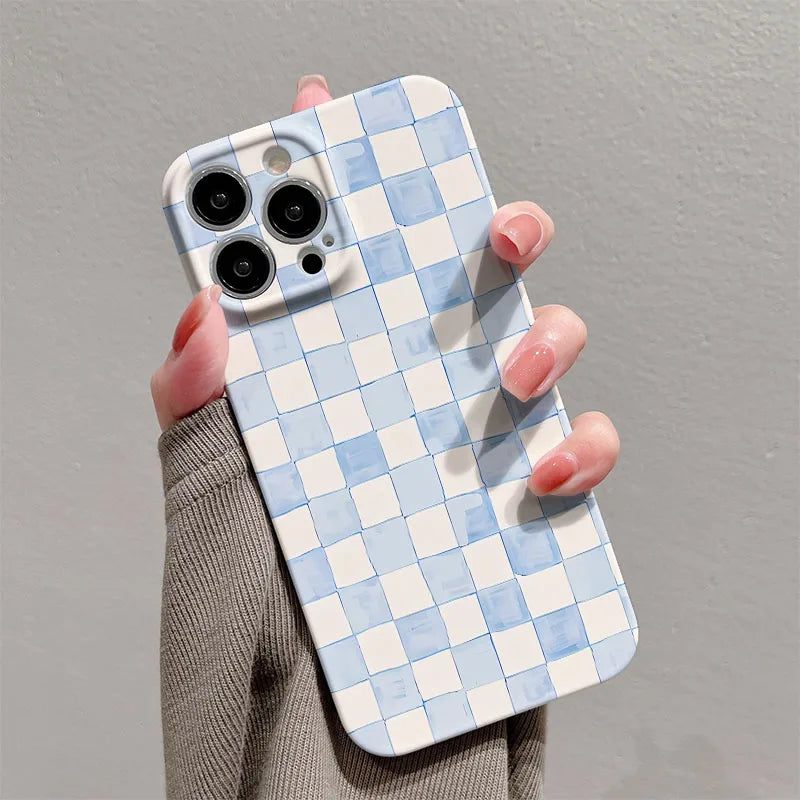 Phone case with blue and white checkered pattern held by a person against a gray background