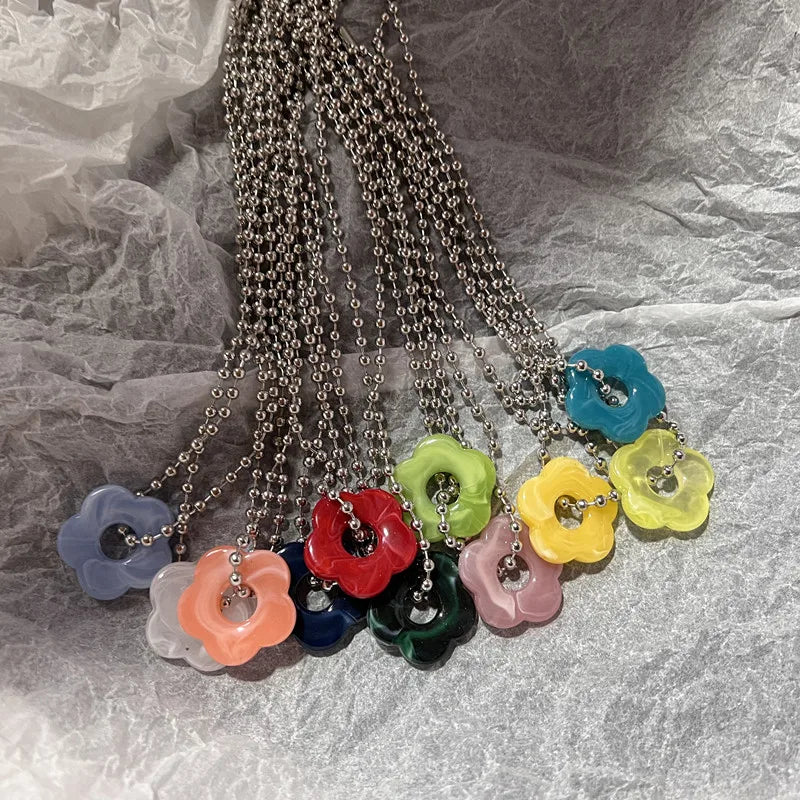 Necklace with colorful flower-shaped pendants on a textured gray background