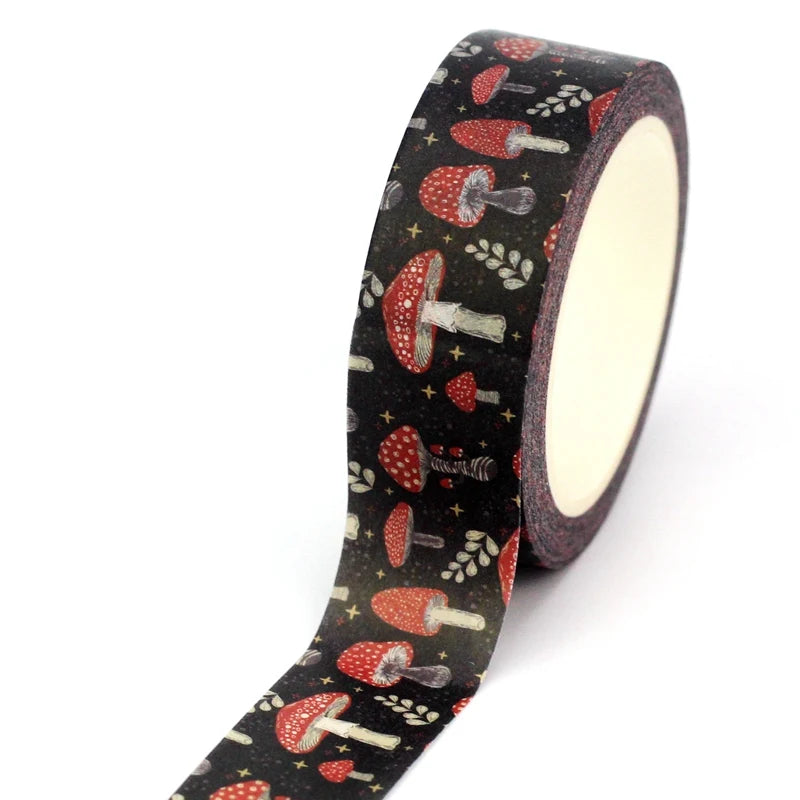A roll of black washi tape with a repeating pattern of red and white mushrooms, small gray birds, and tiny gold stars, shown on a plain white background.