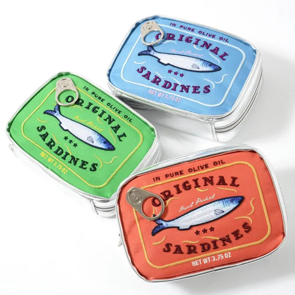 Three square metal tins with pull-tab lids, printed with colorful sardine label artwork, arranged on a white background. The lids show green, light blue, and coral-red designs with the words 'Original Sardines' and 'In Pure Olive Oil.